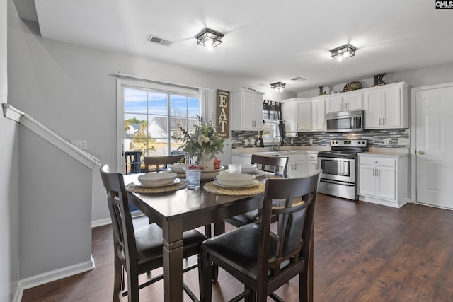 dining area with sink and dark hardwood / wood-style flooring