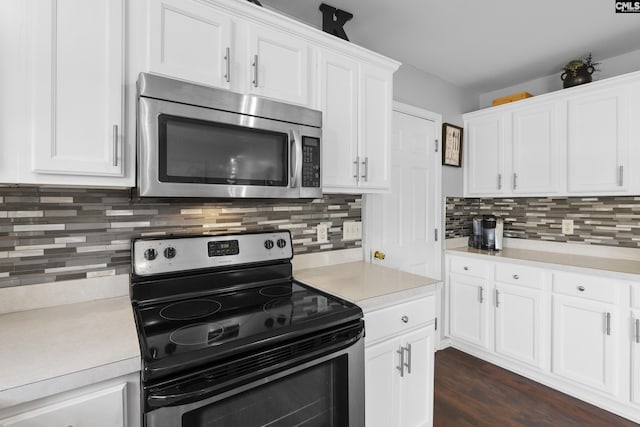 kitchen featuring appliances with stainless steel finishes, decorative backsplash, dark wood-type flooring, and white cabinets