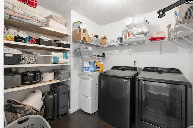 laundry room featuring dark hardwood / wood-style floors, washing machine and dryer, and a textured ceiling