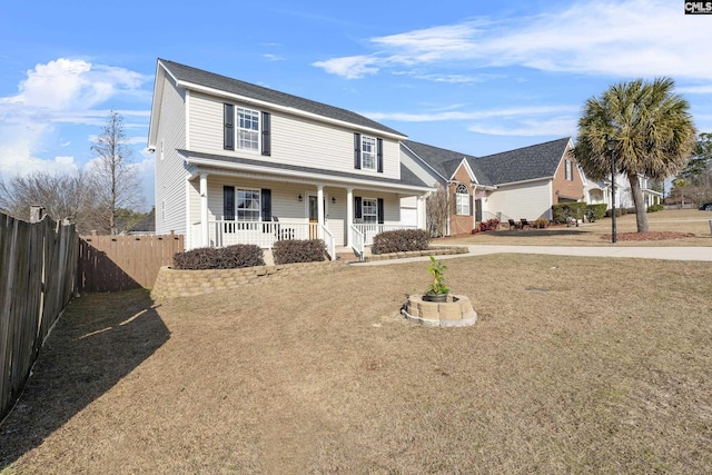 front facade featuring covered porch and a front yard