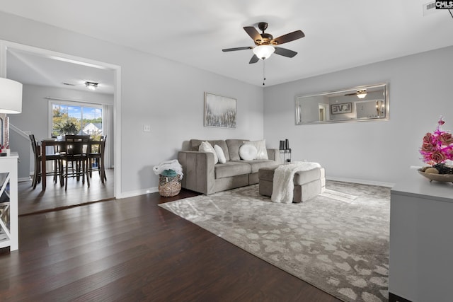 living room with dark hardwood / wood-style floors and ceiling fan