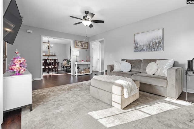 living room featuring ceiling fan with notable chandelier and wood-type flooring