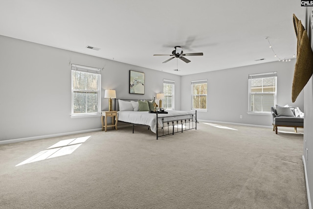 bedroom with multiple windows, light colored carpet, and ceiling fan