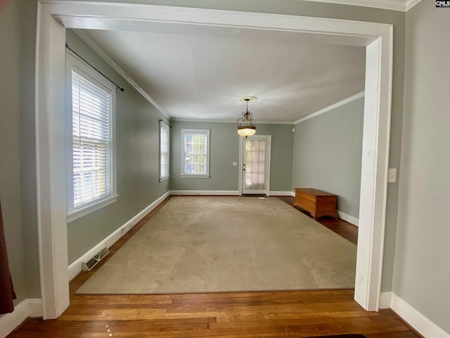 interior space with hardwood / wood-style floors, a healthy amount of sunlight, and ornamental molding