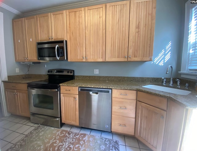 kitchen with stainless steel appliances, stone counters, crown molding, light tile patterned floors, and sink