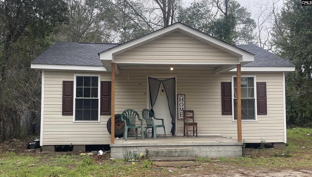 bungalow-style home with a porch and a shingled roof