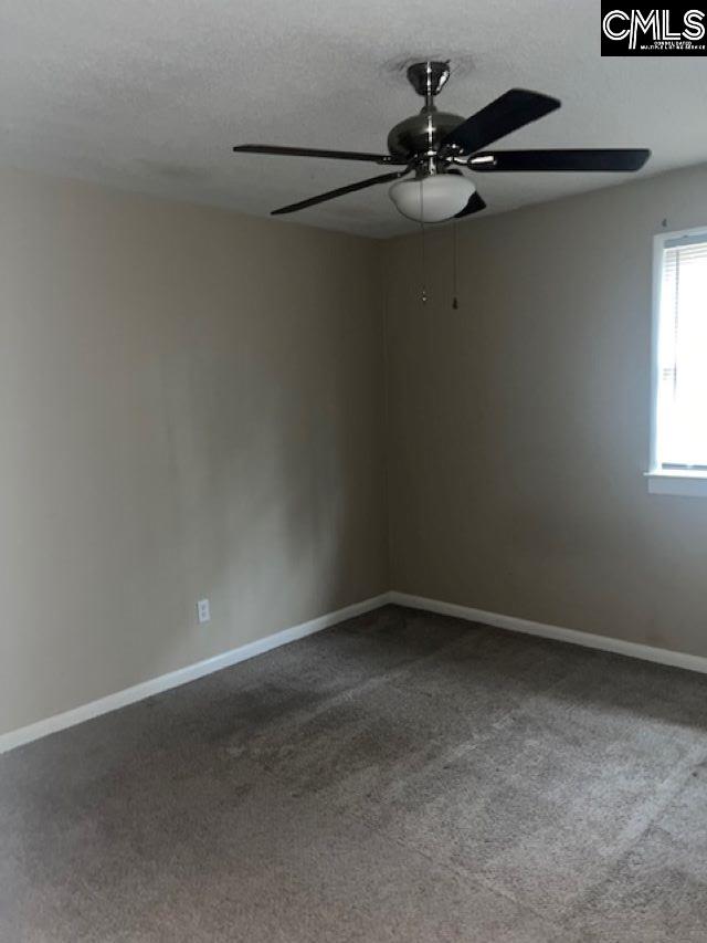 carpeted spare room with a textured ceiling and ceiling fan