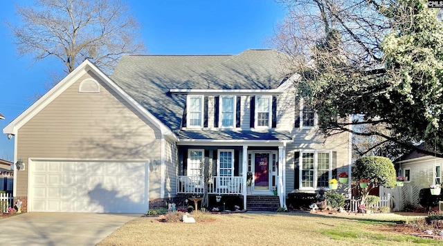 colonial home featuring a front yard and a garage