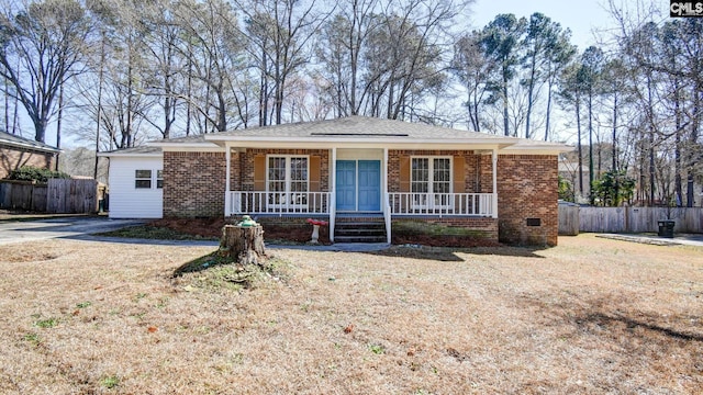 single story home with covered porch and a front yard