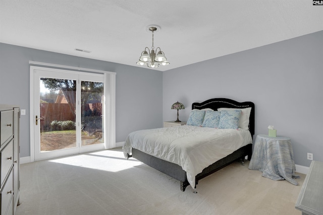 carpeted bedroom featuring a chandelier and access to outside