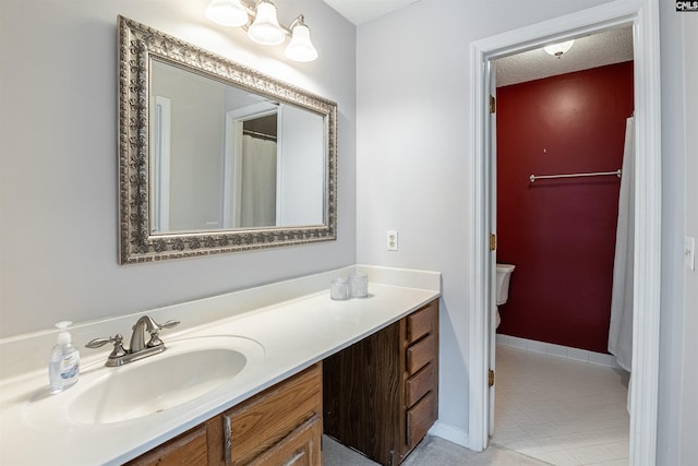 bathroom with toilet, a textured ceiling, tile patterned floors, and vanity