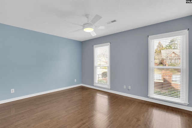 spare room with ceiling fan, a textured ceiling, and dark hardwood / wood-style flooring