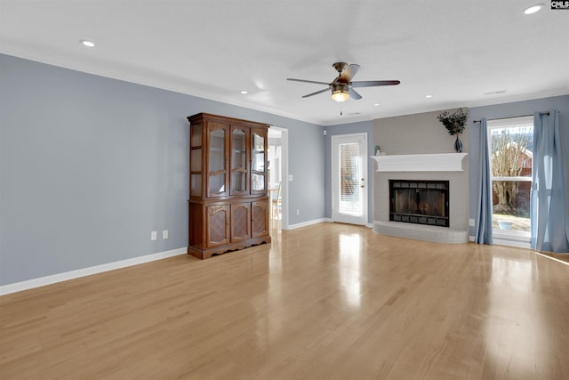 unfurnished living room featuring a fireplace, ornamental molding, ceiling fan, and light hardwood / wood-style floors