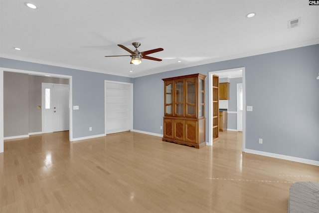 unfurnished living room featuring ceiling fan, light wood-type flooring, crown molding, and built in features