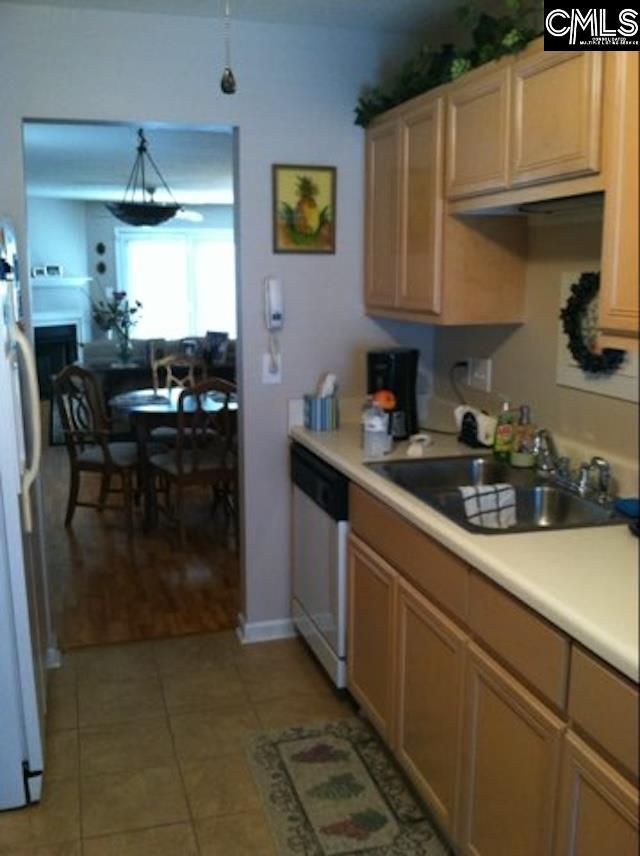 kitchen featuring dishwashing machine, decorative light fixtures, white fridge, light tile patterned floors, and sink