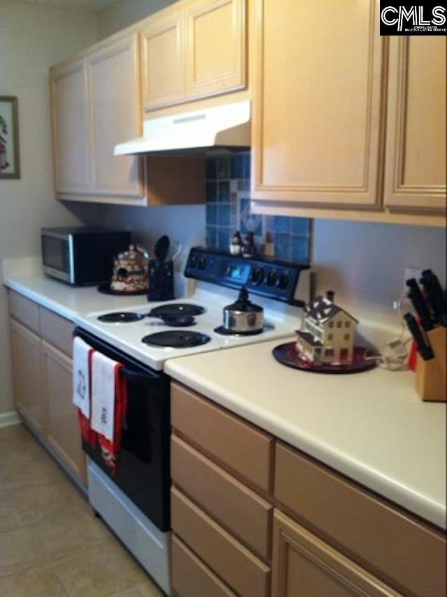 kitchen featuring electric range, light tile patterned floors, and light brown cabinetry