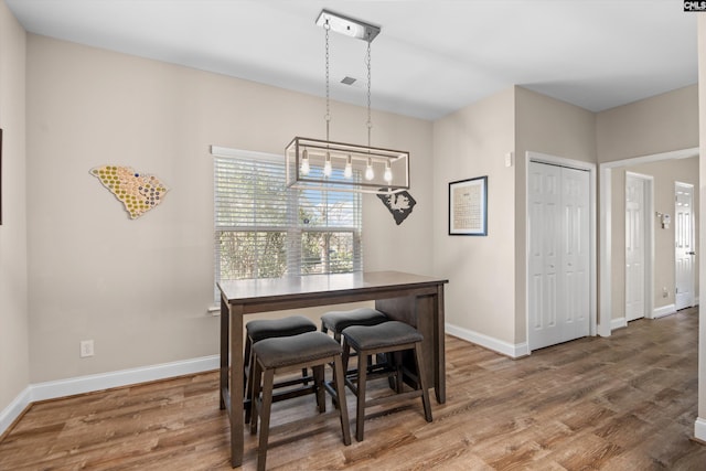 dining space with wood-type flooring