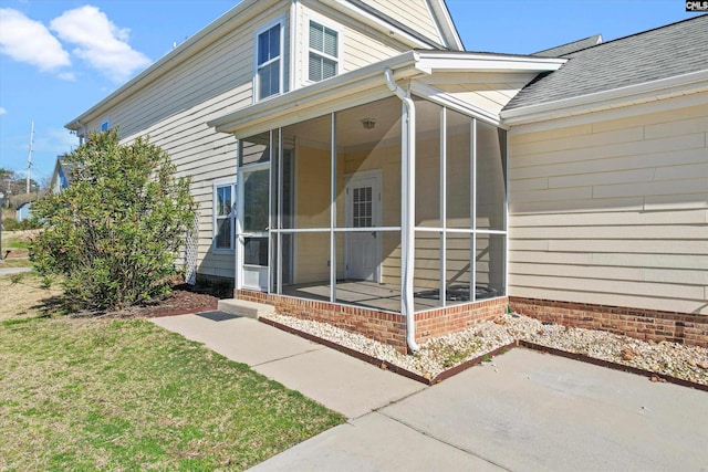 view of exterior entry featuring a lawn