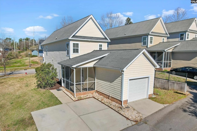 view of front property featuring a front lawn, a garage, and a sunroom