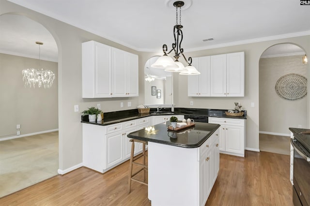 kitchen featuring white cabinets, a kitchen island, and decorative light fixtures