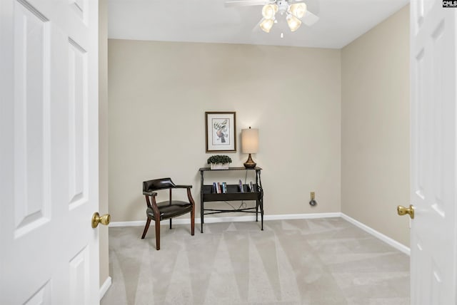 living area with light colored carpet and ceiling fan