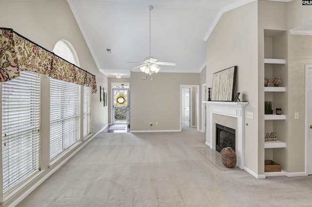 unfurnished living room with a fireplace, high vaulted ceiling, built in shelves, and light colored carpet