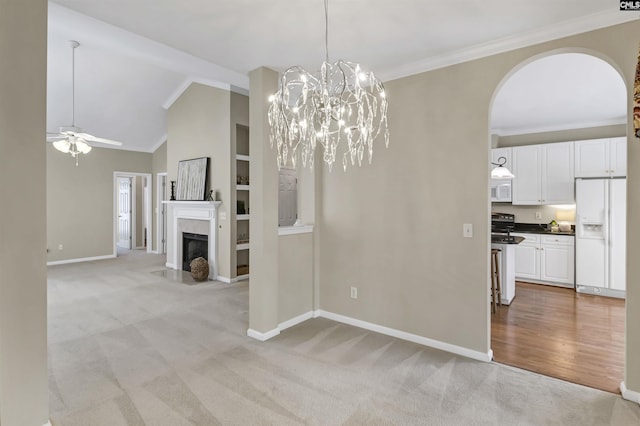 unfurnished dining area featuring vaulted ceiling, crown molding, light colored carpet, and ceiling fan