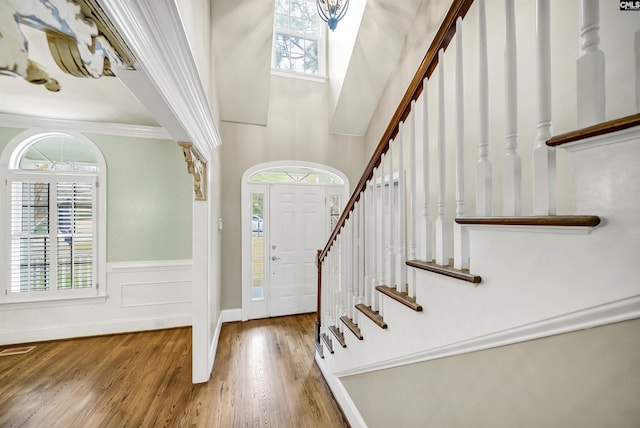 foyer entrance with hardwood / wood-style floors and crown molding