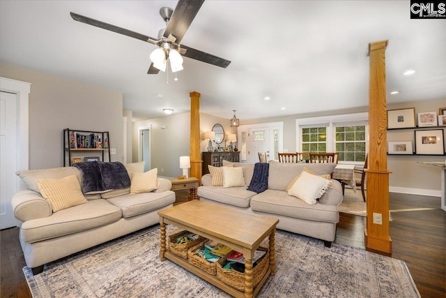 living room with decorative columns, ceiling fan, and dark hardwood / wood-style flooring