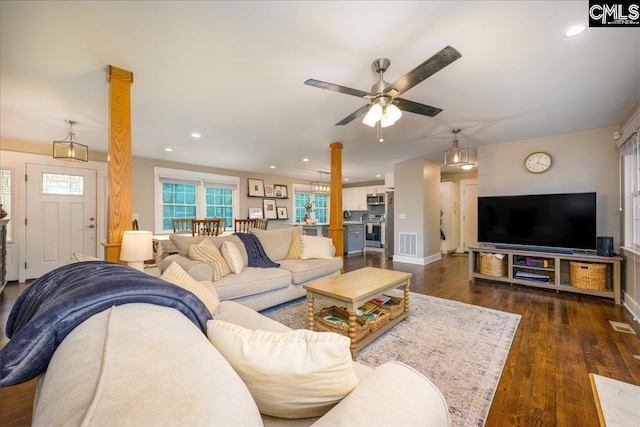 living room with ceiling fan, decorative columns, and dark hardwood / wood-style floors