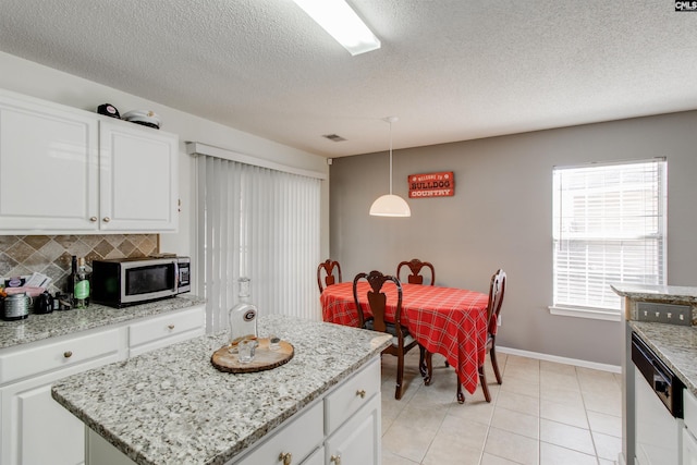 kitchen with white cabinetry, a kitchen island, stainless steel appliances, and decorative light fixtures