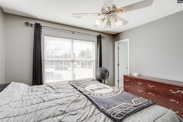 bedroom with ceiling fan and a textured ceiling