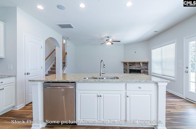 kitchen featuring stainless steel dishwasher, sink, white cabinetry, and a center island with sink