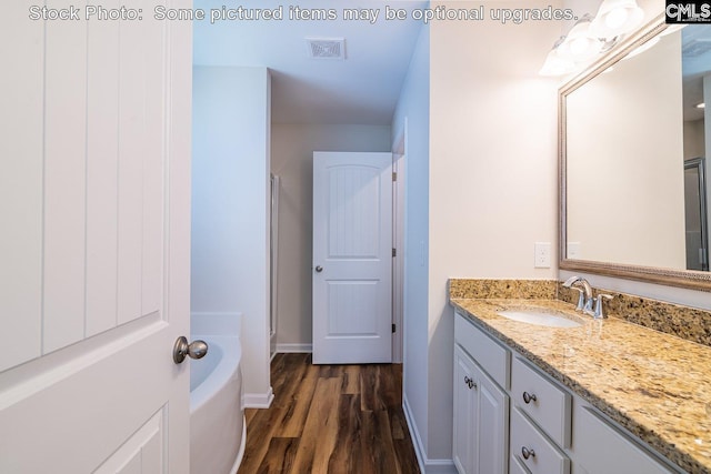 bathroom with hardwood / wood-style floors, independent shower and bath, and vanity