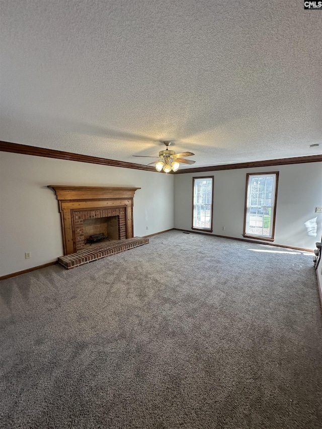 unfurnished living room featuring a fireplace, carpet, ceiling fan, a textured ceiling, and crown molding