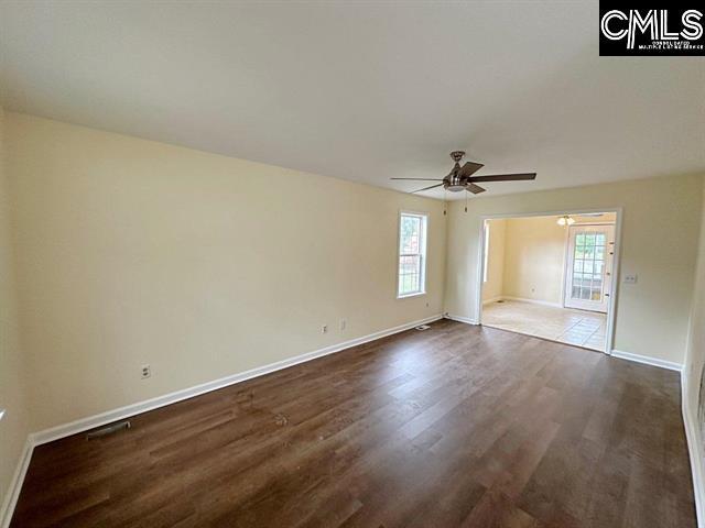 spare room featuring ceiling fan and dark wood-type flooring