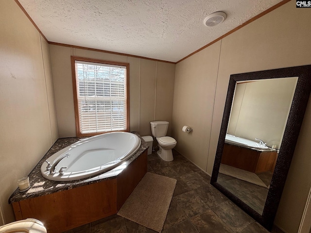 bathroom featuring a tub, crown molding, toilet, and a textured ceiling