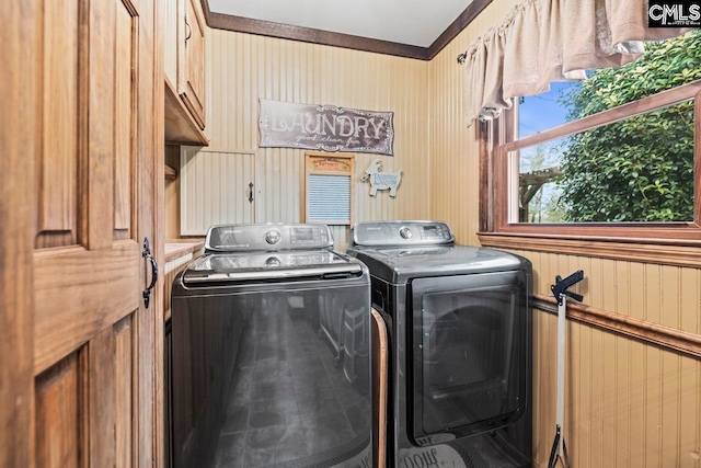 clothes washing area with independent washer and dryer and cabinets