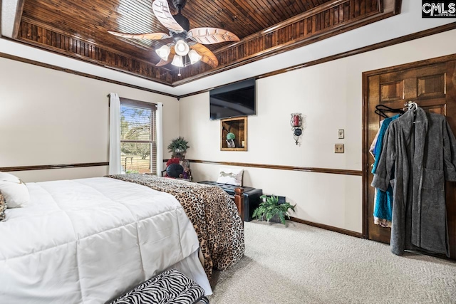 carpeted bedroom with crown molding, wooden ceiling, ceiling fan, and a raised ceiling