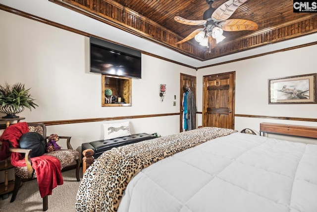 bedroom featuring a tray ceiling, carpet flooring, ceiling fan, wood ceiling, and ornamental molding