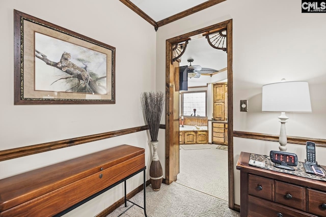 corridor featuring ornamental molding and light colored carpet