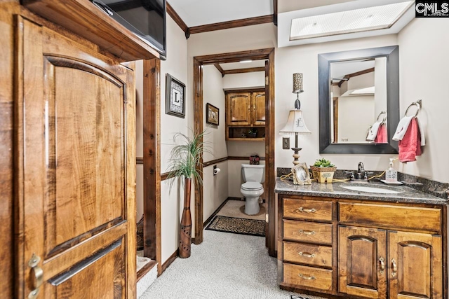 bathroom with vanity, crown molding, and toilet