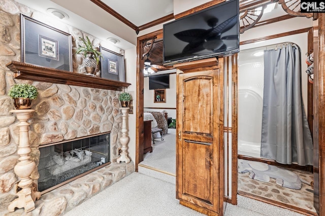 carpeted living room with ornamental molding and a fireplace