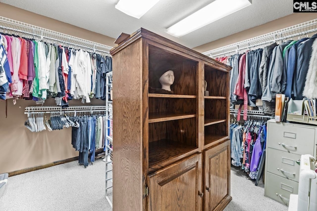 walk in closet featuring light carpet