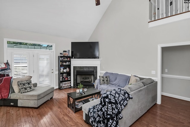 living room featuring a tile fireplace, high vaulted ceiling, and hardwood / wood-style floors