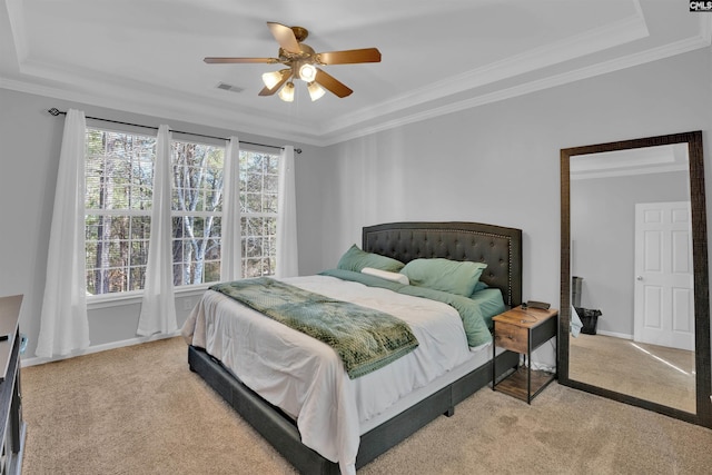 bedroom with light carpet, a raised ceiling, and ornamental molding