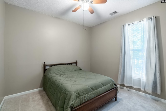 carpeted bedroom featuring a textured ceiling and ceiling fan