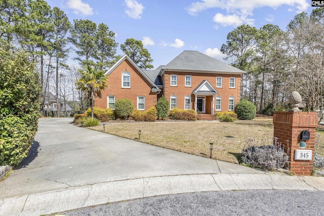 view of front facade featuring a front yard and brick siding