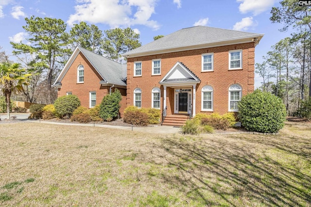 view of front of property with brick siding and a front lawn