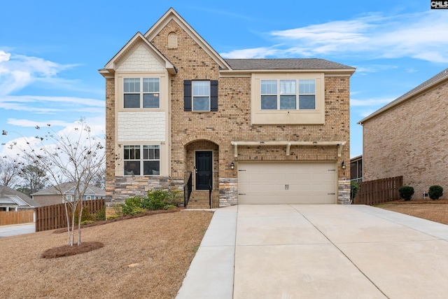 view of front of home featuring fence, brick siding, stone siding, driveway, and an attached garage